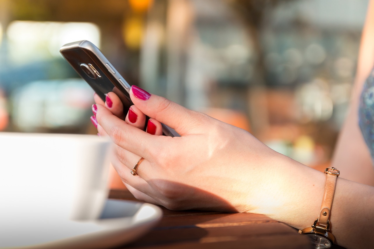 hænder der holder mobiltelefon